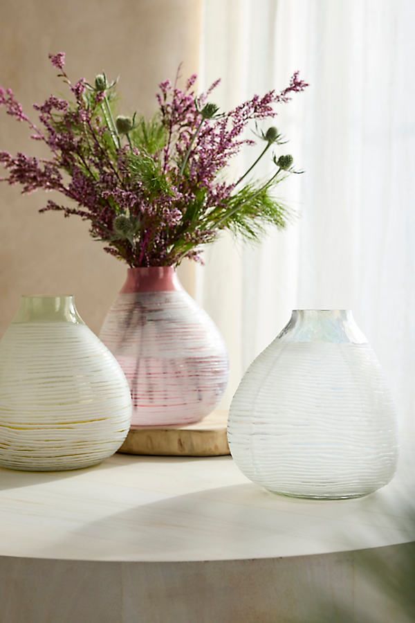 three vases with flowers in them sitting on a table