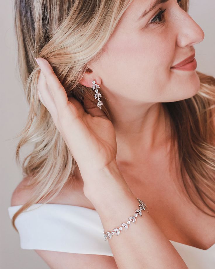 One of our most popular styles, our Sydney Floral CZ Earrings are handcrafted with CZ stones in a floral design. Artfully designed, you'll want to wear these earrings long after your wedding day. Cubic zirconias. Measures 1.25" long Available in pierced or clip version Matching bracelet available Hypoallergenic, lead-free & nickel-free Style #4140 Photo Credit: Han Designed & Hunter Hennes Photography Formal Dangle Flower Earrings With Cubic Zirconia, Elegant Design Cubic Zirconia Diamond Earrings For Gift, Elegant Cubic Zirconia Diamond Earrings For Gift, Dazzling Cubic Zirconia Linear Earrings For Wedding, Formal Flower Earrings With Cubic Zirconia, Anniversary Cubic Zirconia Hoop Earrings With Elegant Design, Anniversary Hoop Earrings With Cubic Zirconia, Elegant Flower Earrings With Sparkling Stones For Wedding, Elegant Wedding Flower Earrings With Sparkling Stones