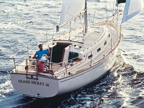 a man is sitting on the deck of a small sailboat in the middle of the ocean