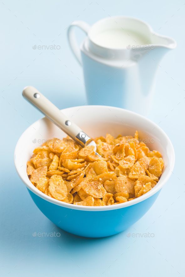 cereal in a bowl with a spoon and milk pitcher on the side - stock photo - images