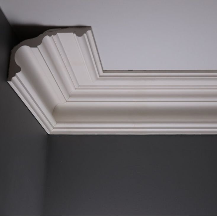 the corner of a ceiling with white paint and molding on it's edges