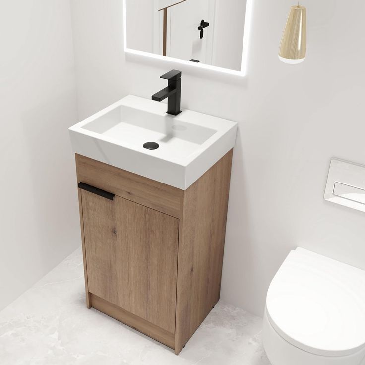 a white toilet sitting next to a sink in a bathroom under a large mirror above it