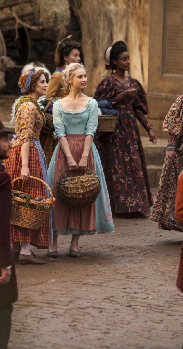 a group of people standing around each other with baskets on their heads and one woman holding a basket in her hand