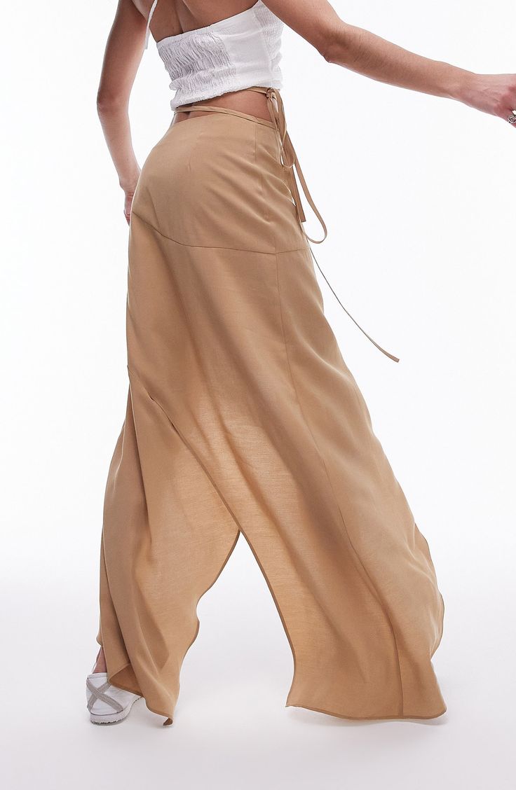 This flowy, asymmetric maxi skirt flaunts strappy ties at the waist and a leg-flaunting handkerchief hem that moves with every step you take. Ties at side 90% rayon, 10% polyester Machine wash, line dry Imported Summer Asymmetrical Maxi Skirt With Side Slits, Summer Asymmetrical Skirt With Tie Waist, Summer Asymmetrical Skirt With Side Slits, Asymmetrical Skirt With Side Slits For Summer, Flowy Maxi Skirt With Asymmetrical Hem, Flowy Wrap Skirt With Handkerchief Hem For Spring, Tie Waist Long Skirt For Summer, Bohemian Handkerchief Hem Bottoms For Beach, Elegant Spring Bottoms With Handkerchief Hem