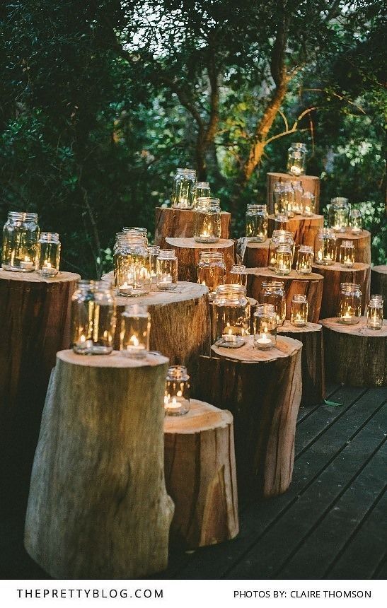 many candles are lit on wooden logs