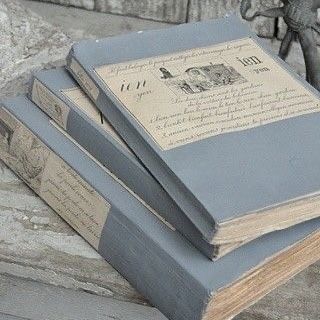 three books sitting on top of a wooden table next to a small figurine