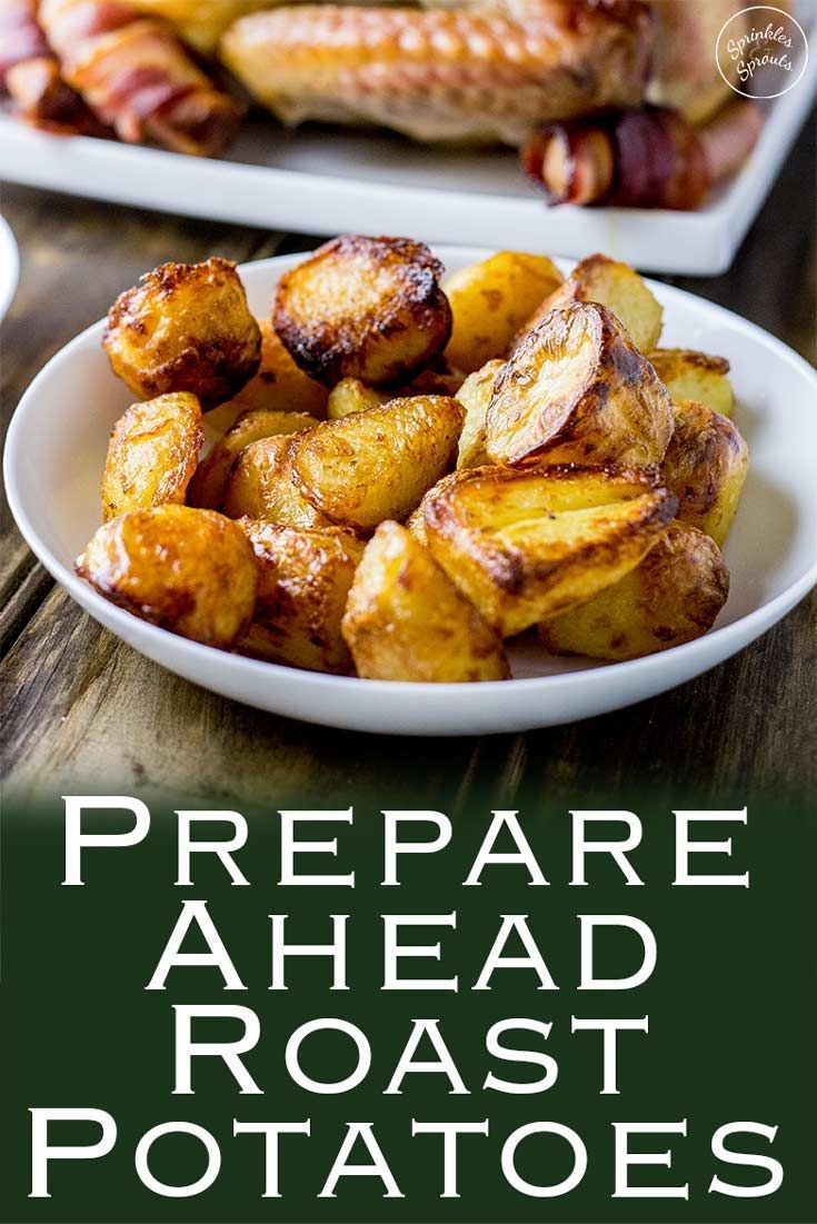 two white plates filled with roast potatoes on top of a wooden table