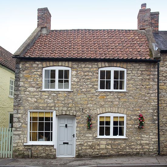 an old brick house with white windows and shutters