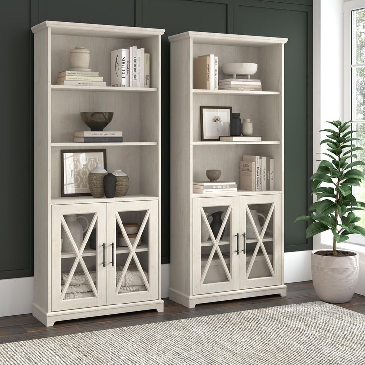 two white bookcases sitting next to each other on top of a carpeted floor