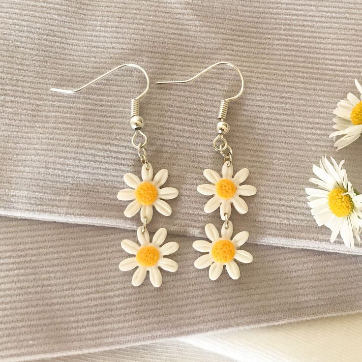 These adorable white daisy chain dangle earrings are the perfect unique summery accessory. The polymer clay they are made from is very lightweight and comfortable, and each pair is slightly different due to the nature of handmade products. White Dangle Flower Earrings For Spring, Minimalist White Jewelry For Spring, White Daisy-shaped Jewelry For Spring, Dainty White Earrings For Spring, White Daisy-shaped Spring Jewelry, White Flower Charm Earrings For Everyday, White Daisy Jewelry For Everyday, White Daisy-shaped Everyday Jewelry, Dainty White Dangle Flower Earrings