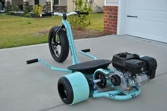 an electric scooter is parked on the concrete in front of a garage door