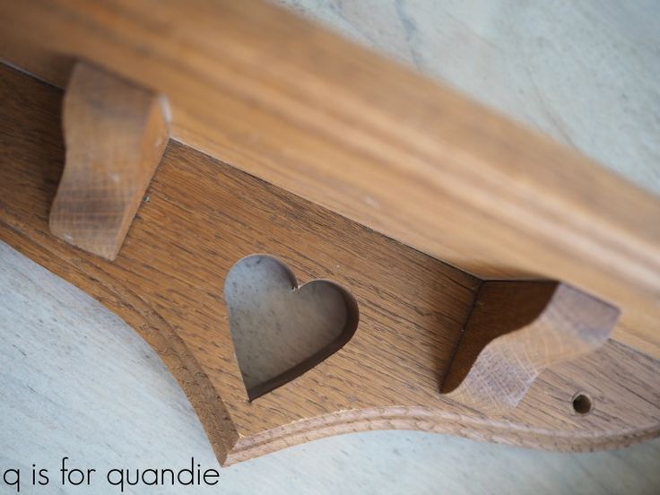 a wooden shelf with two hearts cut out of it