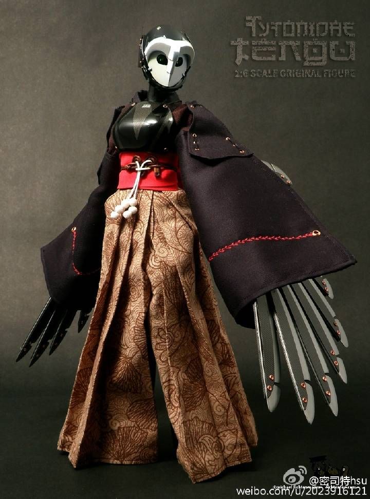 the doll is wearing an elaborate costume and holding two large metal forks in its hands