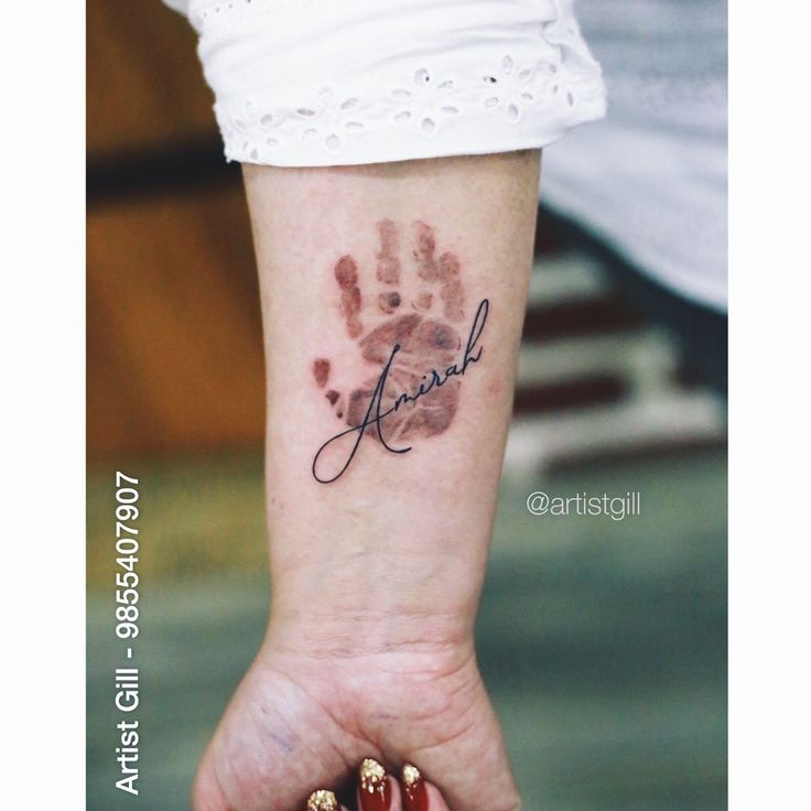 a woman's hand with a small tattoo on it