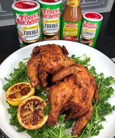 a white plate topped with chicken next to oranges and ketchup