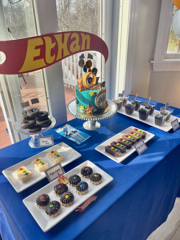 a table topped with lots of cupcakes and cakes