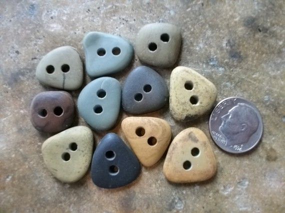 a pile of different colored buttons sitting on top of a stone floor