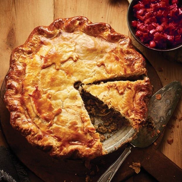 a pie on a cutting board with a slice missing