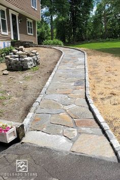 a stone walkway in front of a house