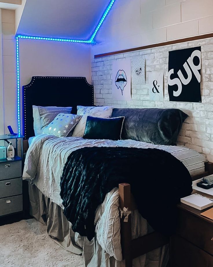 a bedroom with white brick walls and blue lights on the ceiling, along with a bed