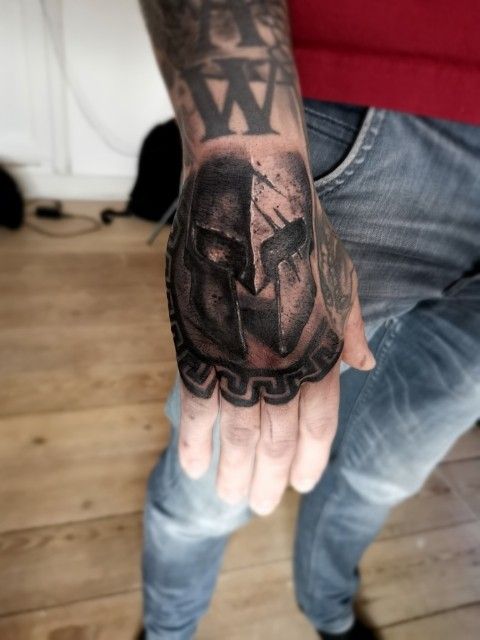 a man's hand with a tattoo on it that has an image of a person holding