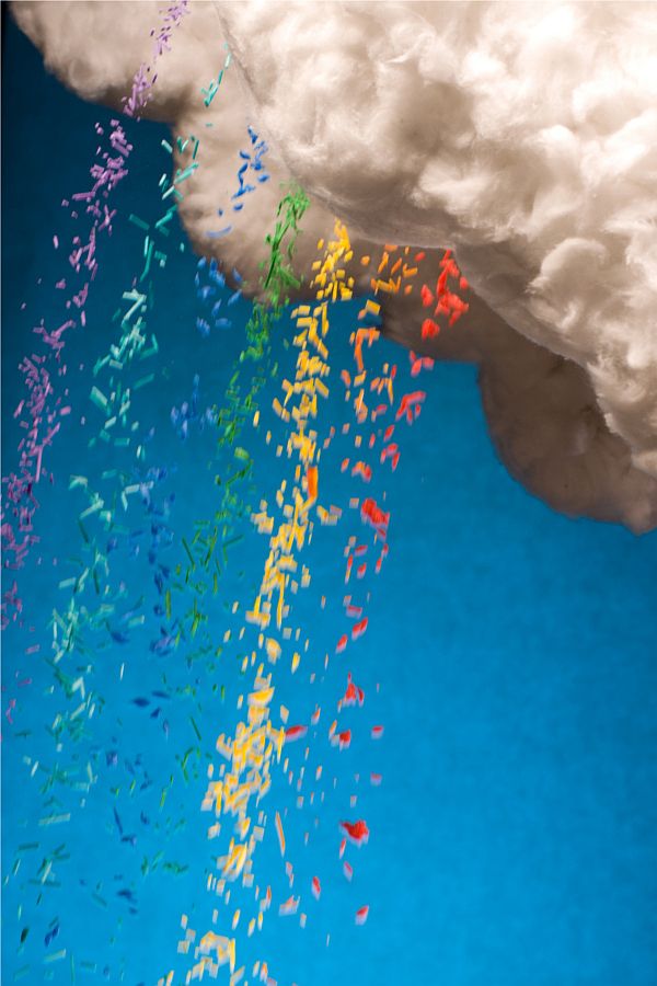 colorful confetti is falling from the clouds into the water