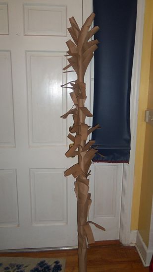 a tall cardboard tree is standing in front of a door