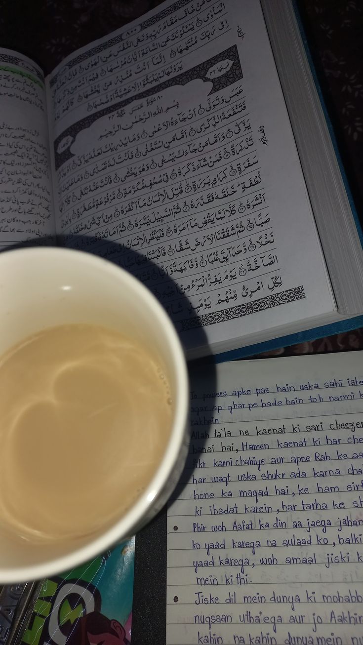 a cup of coffee sitting next to an open book