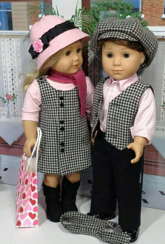 two dolls standing next to each other holding shopping bags