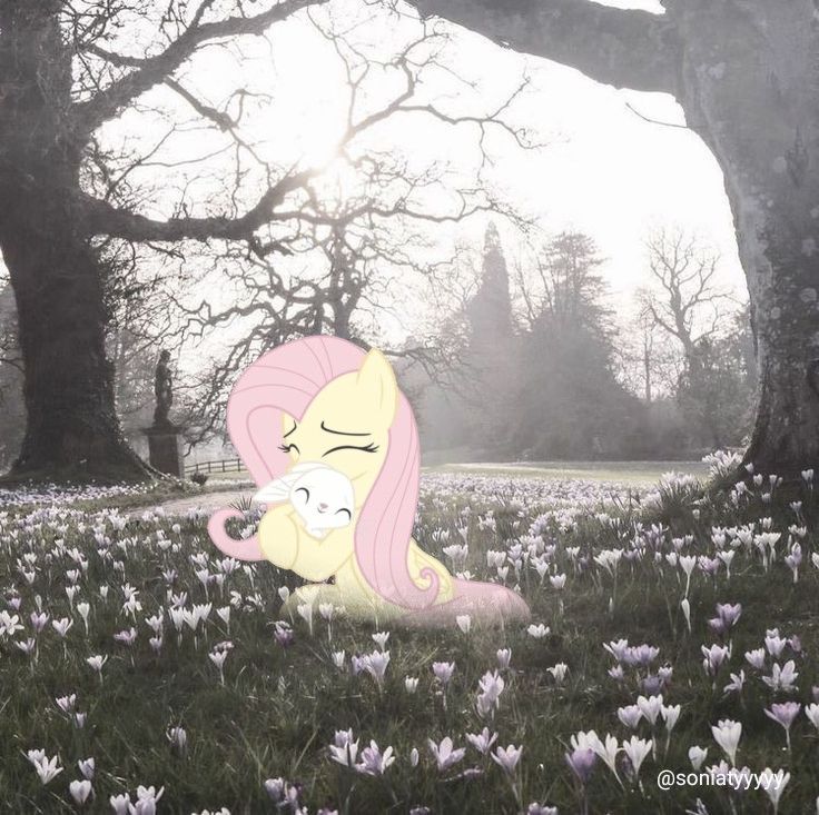 a pink pony sitting in the middle of a field with flowers on it's ground