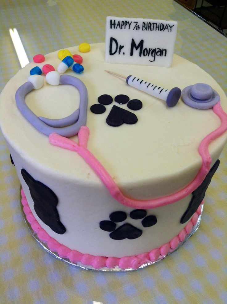 a decorated birthday cake with a stethoscope and dog paw prints on it