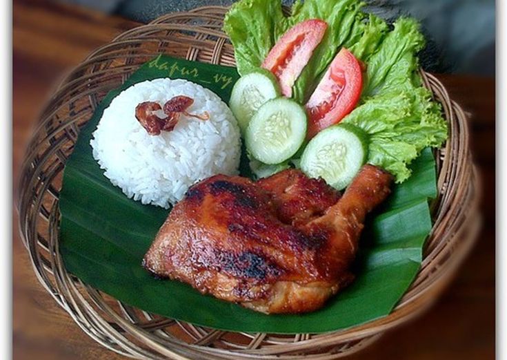 a plate with meat, rice and veggies on it sitting on a table