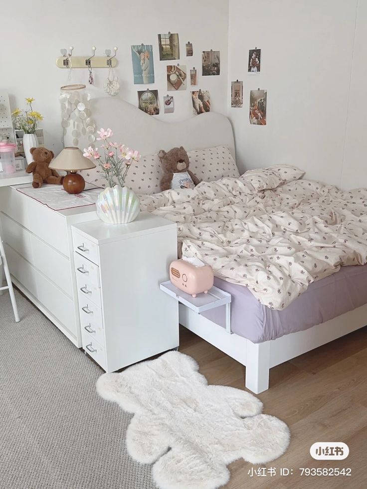 a bedroom with a bed, dresser and teddy bear on the floor next to it