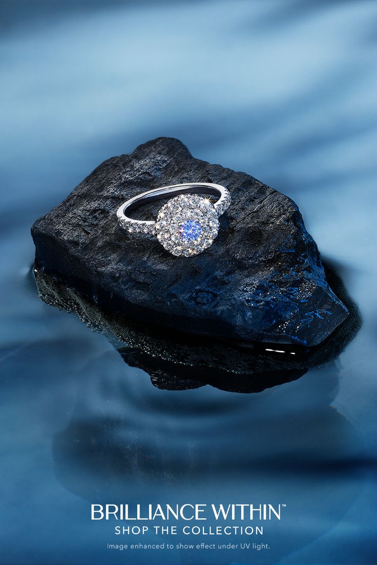 an engagement ring sitting on top of a rock in the middle of water with text, bridalnce within shop the collection