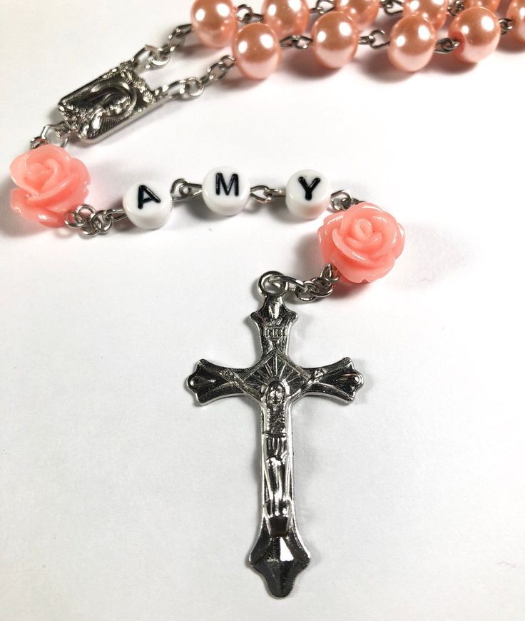 Hello and welcome. This rosary can be personalized with a baby's name or initial letters, ideal count of letters is 3 to 5. I recommend to choose a short version of baby's name for better look. Necklace measures 21 inches, it can grow with baby or can be put away as a keepsake memory for later. This will make a perfect baptism/ christening gift! Spiritual Pink Jewelry For Birthday, Personalized Silver Rosary For First Communion, Personalized Pink Beaded Jewelry, Customizable Pink Jewelry For Personalized Gift, Personalized Pink Jewelry For Personalized Gift, Pink Beaded Spiritual Rosary, Personalized Rosary Bracelet With Round Beads For Birthday, Handmade Pink Spiritual Rosary, Mother's Day Gift Rosary With 8mm Beads