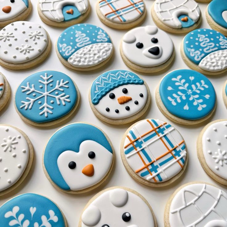 decorated cookies with frosting and icing are arranged on a white surface, including snowmen