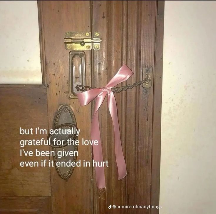 a door with a pink ribbon tied to it and an old fashioned lock on the front