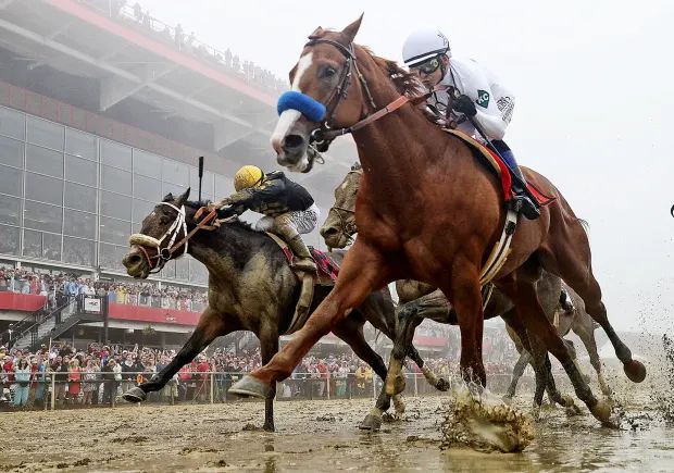 three jockeys are racing horses in the mud at a race track as people watch