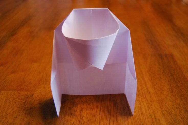 an origami vase sitting on top of a wooden table