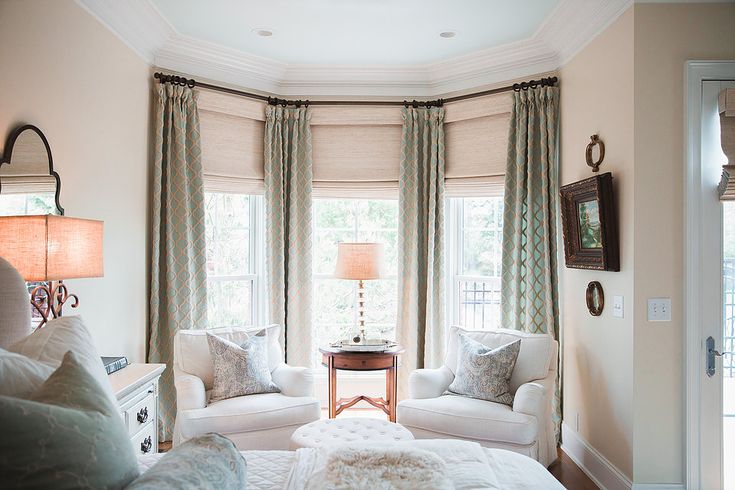 a living room with white furniture and curtains on the windowsill, along with two couches