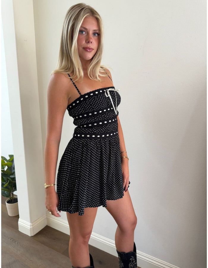 This black mini dress has white polka-dots and delicate lace trim for a cute and playful look. Adjustable self-tie white lace adds a touch of charm, while black lace detailing on the bust and midsection adds an elegant touch. With spaghetti straps and a flowy fit, this dress is both comfortable and stylish. It also features a zipper in the back for easy dressing. Product details: Model is wearing a size small Self: 100% Rayon Lining: 100% Polyester Easy Dressing, Black Mini Dress, Dress Romper, New Arrival Dress, Black Mini, White Polka Dot, Simple Dresses, Mini Black Dress, Skirt Pants