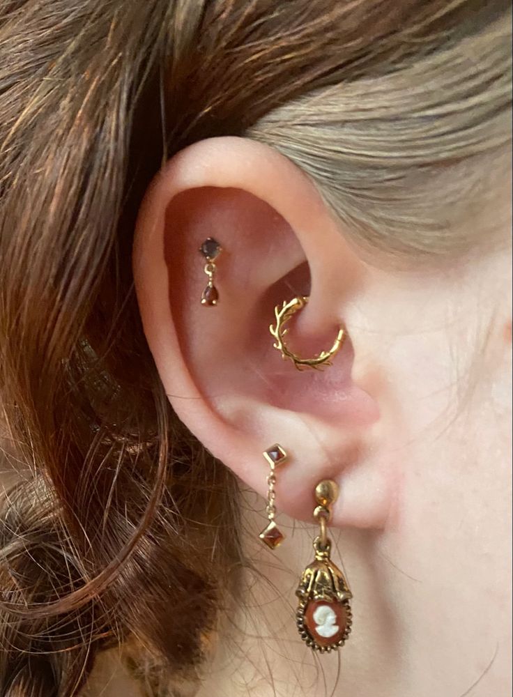 a close up of a person's ear with two different types of earrings on it