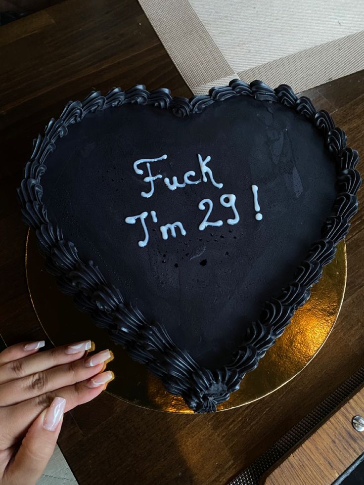 a heart shaped cake with the words f k i m 29 written on it