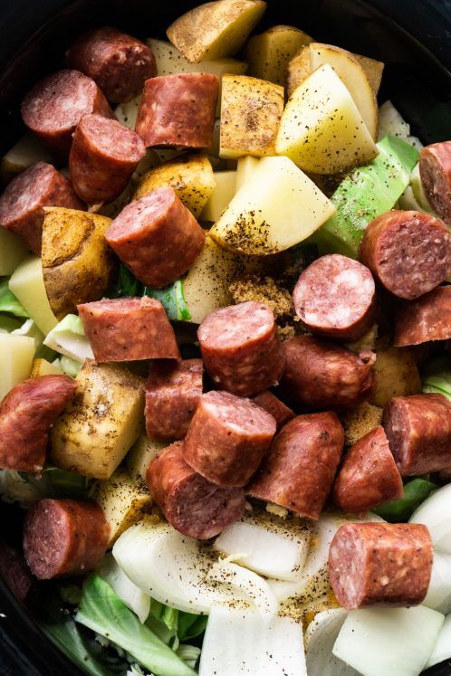 a bowl filled with sausage, potatoes and lettuce