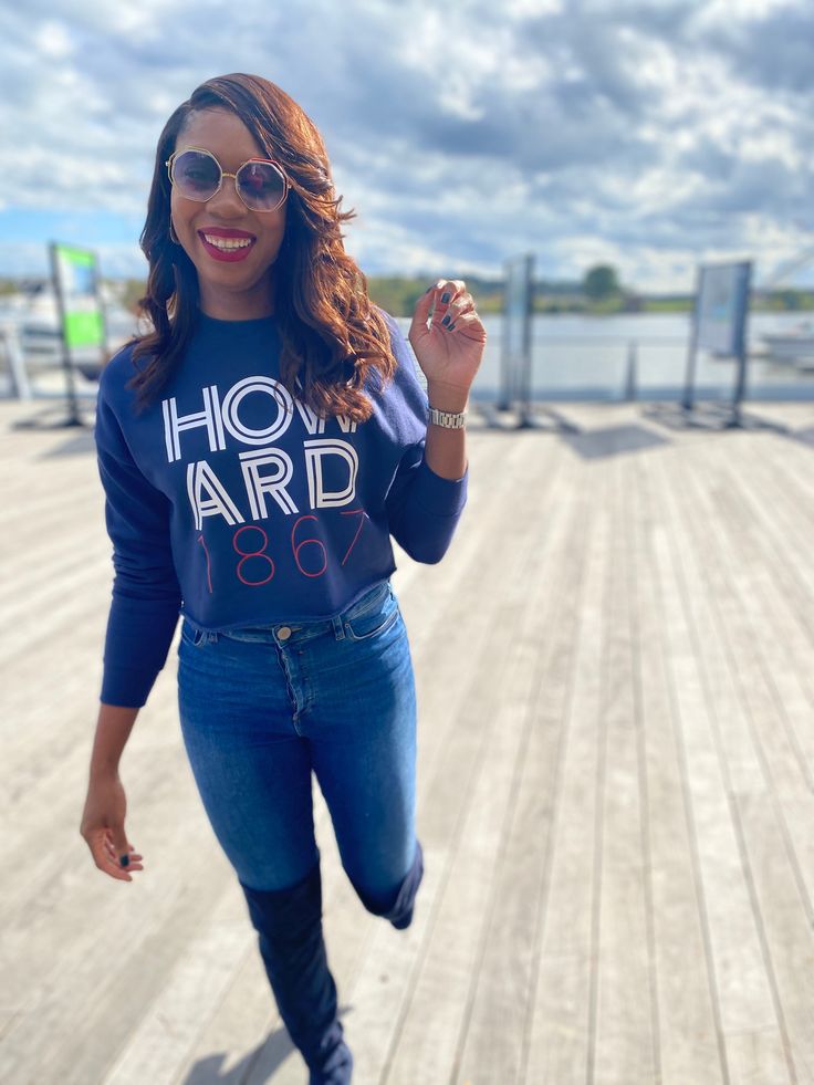 a woman is running on the boardwalk with her hand up in the air and smiling