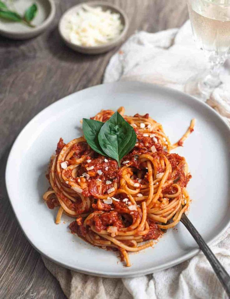 spaghetti with tomato sauce and basil on a white plate