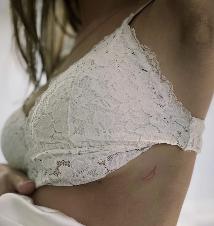 a close up of a woman's stomach wearing a white bra with lace on it