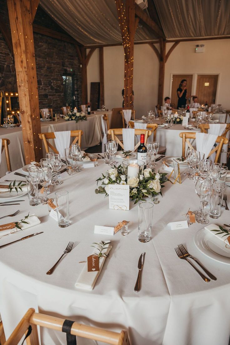 the table is set for an event with white linens