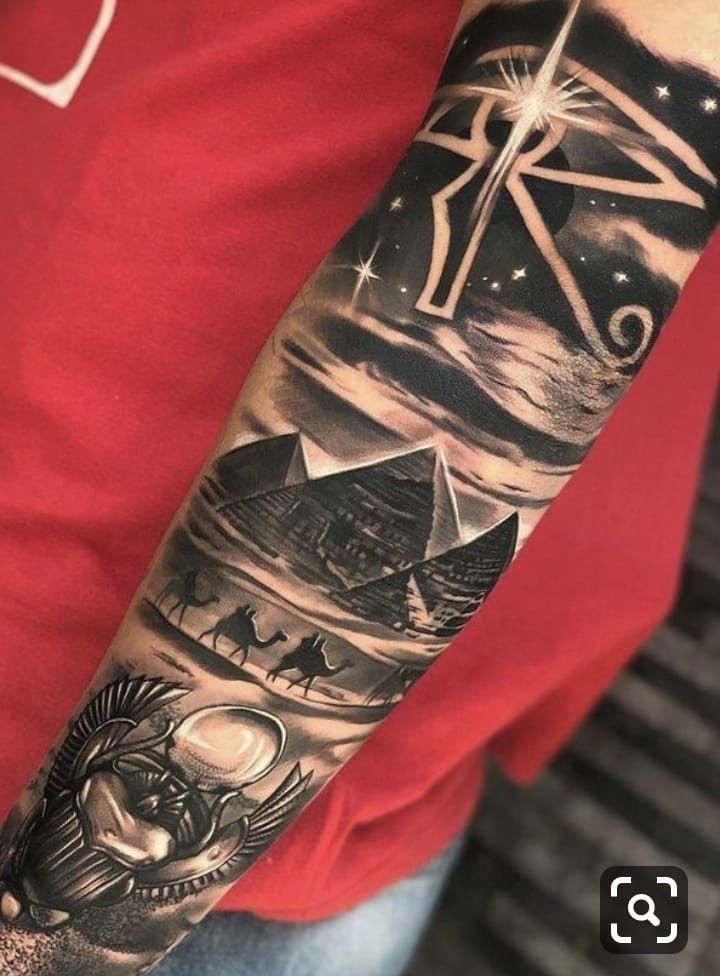 a man's arm with an image of the sun and pyramids on it