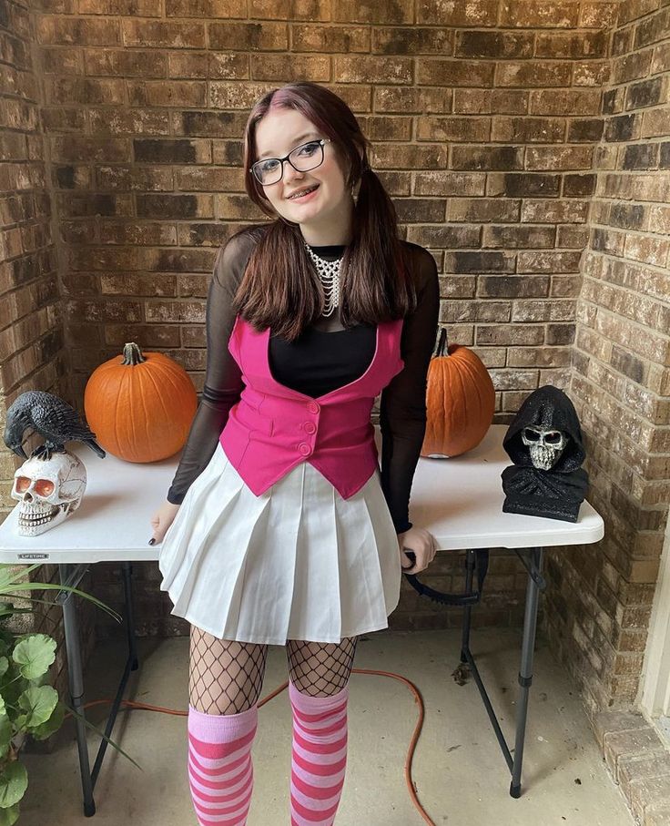 a woman wearing tights and stockings standing in front of a table with pumpkins